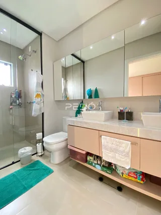 Foto de um banheiro moderno com box de vidro e louças brancas.