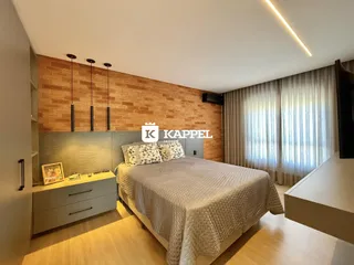 Quarto com cama grande e parede de tijolos aparentes.