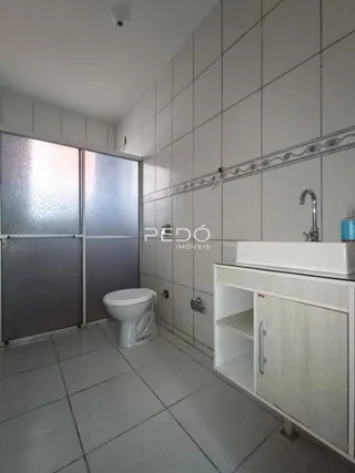 Foto de um banheiro com piso de cerâmica e azulejos brancos.