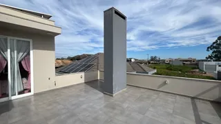 Vista externa de uma varanda com piso de cerâmica e painéis solares visíveis.