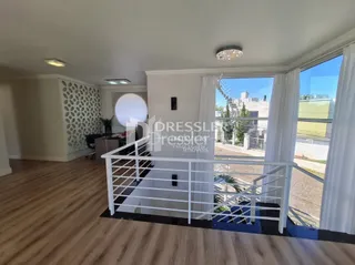 Sala de estar com piso de madeira clara e porta de vidro.
