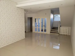 Hall de entrada com paredes brancas e piso claro.