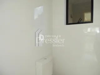 Interior de um banheiro com vaso sanitário branco.