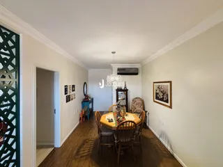 Sala de jantar com piso de madeira e mesa de jantar.