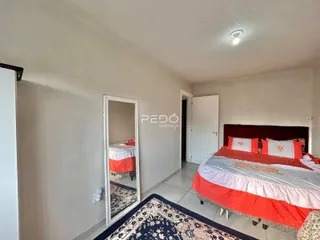 Quarto com cama e espelho em um imóvel no Brasil.