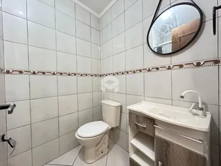Foto de um banheiro com revestimento cerâmico e louças sanitárias.