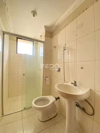 Foto de um banheiro com revestimento cerâmico branco.
