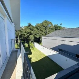 Vista da fachada de uma residência com área verde.