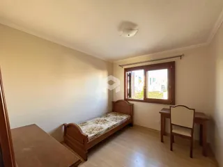 Quarto com cama de madeira e janela em um imóvel no Brasil.