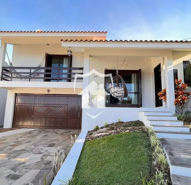 A fachada de uma casa em Lajeado, Brasil, com garagem e jardim.