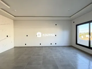 Sala ampla com piso de porcelanato e vista externa.