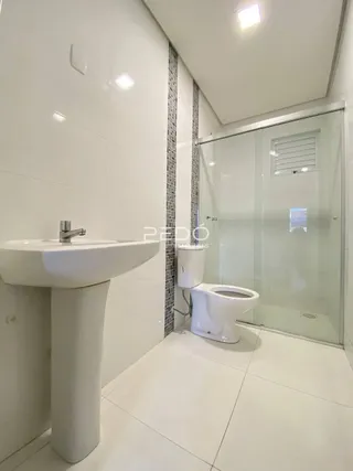 Foto de um banheiro moderno com pia e vaso sanitário.