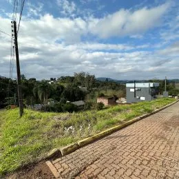 Vista externa de uma estrada com vegetação e céu nublado.