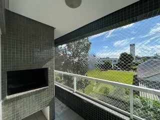 Vista de uma sala com parede de azulejos e uma varanda com vista para o jardim.