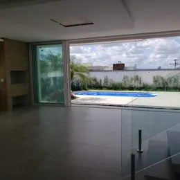 Vista de um ambiente interno com portas de vidro que dão acesso a uma área externa.