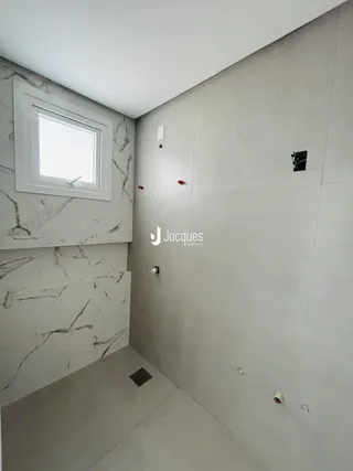 Foto de um banheiro com paredes em mármore e acabamento moderno.