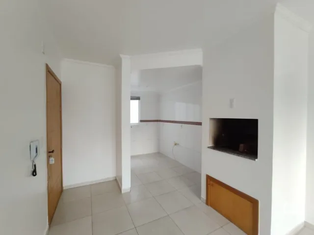 Interior de um ambiente com paredes brancas e piso de cerâmica.