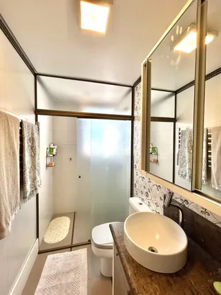 Foto de um banheiro interno com revestimento de azulejos brancos.
