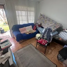 Quarto com cama e cortinas claras em ambiente interno.