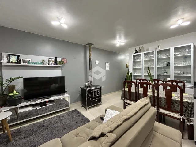 Sala de estar com sofá e área de jantar em imóvel no Brasil.