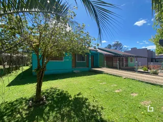 Vista externa de uma residência com jardim e vegetação.
