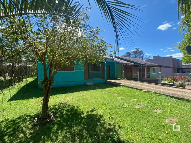 Vista externa de uma residência com jardim e vegetação.
