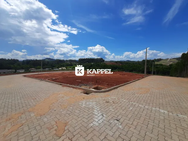 Foto de um lote de terreno com paisagem de colinas ao fundo sob um céu azul.