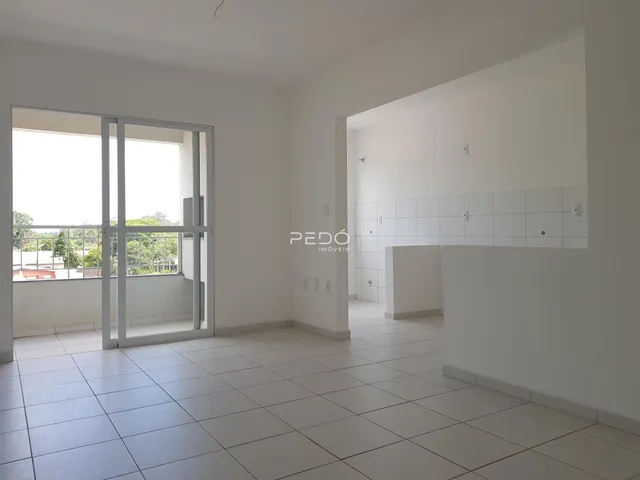 Interior de uma sala com piso de cerâmica e porta de vidro.