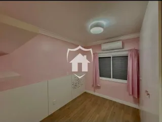 Quarto com paredes rosa e piso de madeira clara.