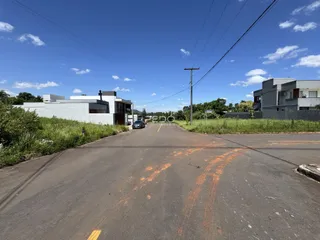Vista da rua pavimentada em Lajeado, Brasil, com casas ao fundo.