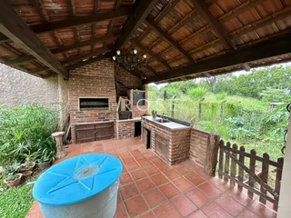 Área externa com piso de tijolo e vista para o jardim.