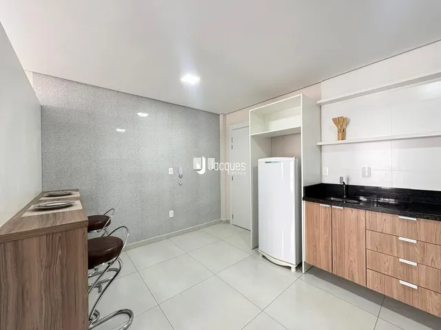 Imagem de uma cozinha moderna com armários e eletrodomésticos em um apartamento.