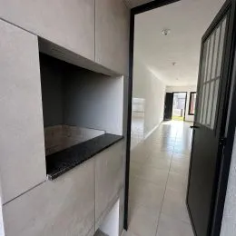 Vista de um corredor interno com paredes brancas.