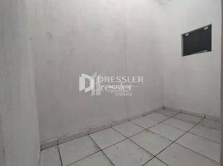 Parede branca e piso de cerâmica em um ambiente interno.
