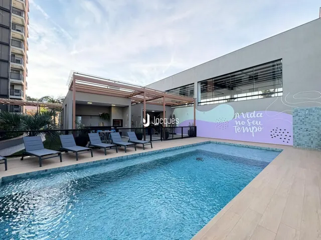 Foto da piscina externa com espreguiçadeiras e área de lazer de uma residência.