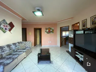 Sala de estar com sofá e televisão em um imóvel no Brasil.