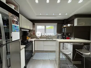 Esta é uma foto de uma cozinha moderna com armários brancos e bancadas claras.