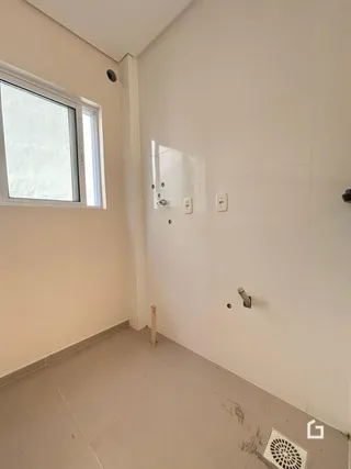 Interior de um ambiente com parede branca e piso claro.