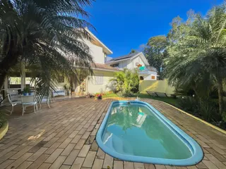 Vista da área externa com piscina e jardim de uma residência em Lajeado.