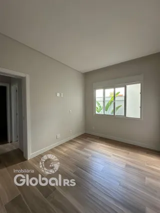 Vista interna de um cômodo com piso de madeira clara e parede cinza na Lajeado.