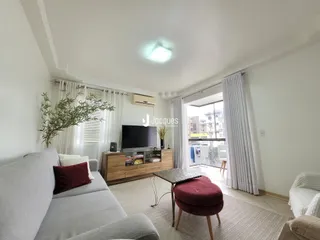 Sala de estar clara com sofá e janela de grande porte.