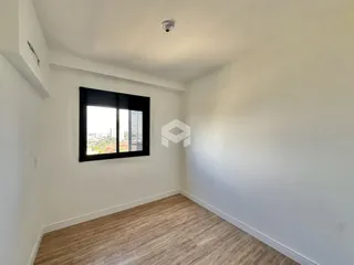 Ambiente interno de um cômodo com piso de madeira e janela para a vista.