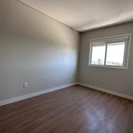 Foto de um cômodo interno com piso de madeira e janela.