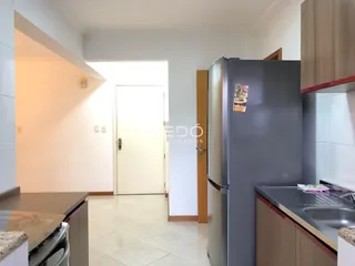 Imagem de uma cozinha moderna com geladeira e armários em um imóvel no Brasil.