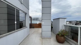 Vista externa de um imóvel com parede branca e área de terraço.