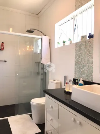 Foto de um banheiro moderno com box de vidro e revestimento cerâmico.