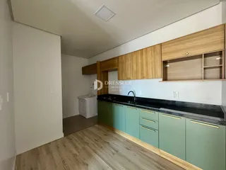 Foto de uma cozinha com armários de madeira e bancada escura.