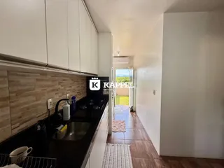 Esta é uma foto da cozinha com armários brancos e bancada escura.