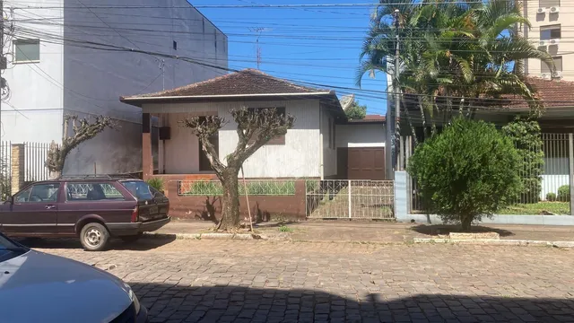 Fachada de uma casa em Lajeado, Brasil, com cerca e árvores.