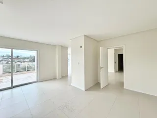 Uma sala ampla com porta de vidro que dá para uma vista externa.